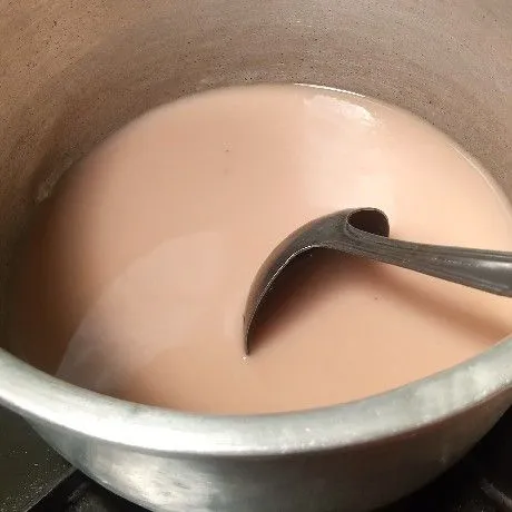 Tuang jadi satu bahan puding coklat di panci.