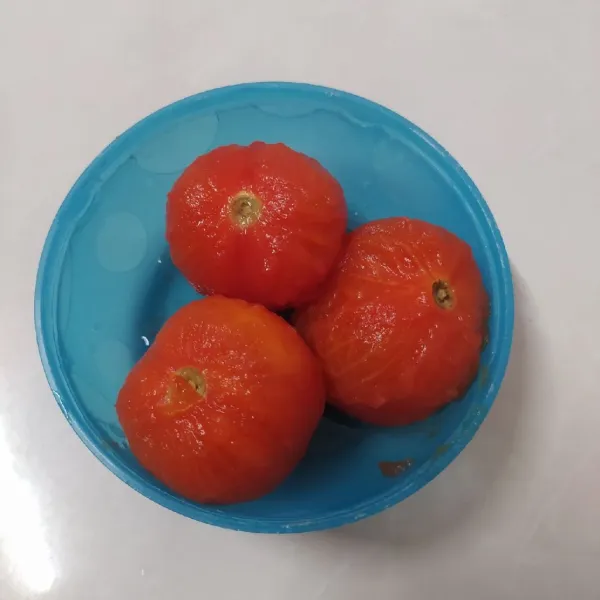 Ambil tomat dan kupas kulit tomat.