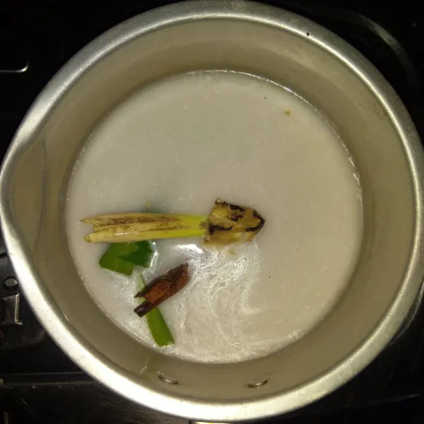 Masukkan santan, jahe bakar, serai, kayu manis dan daun pandan ke dalam panci. Rebus sampai mendidih.