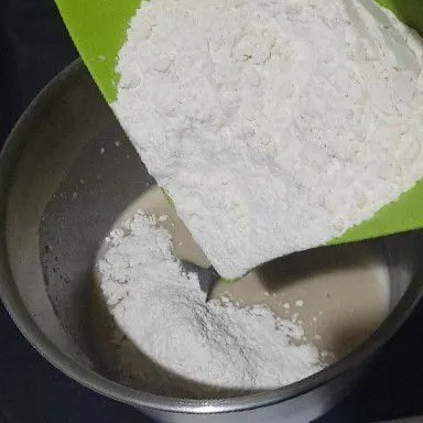 Lalu masukkan 1/2 sisa tepung dan garam, aduk rata.