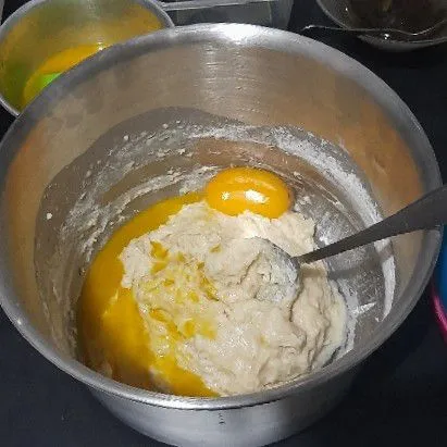 Tambahkan margarin dan kuning telur, aduk hingga rata, lalu tambahkan sisa tepung, uleni hingga kalis elastis.