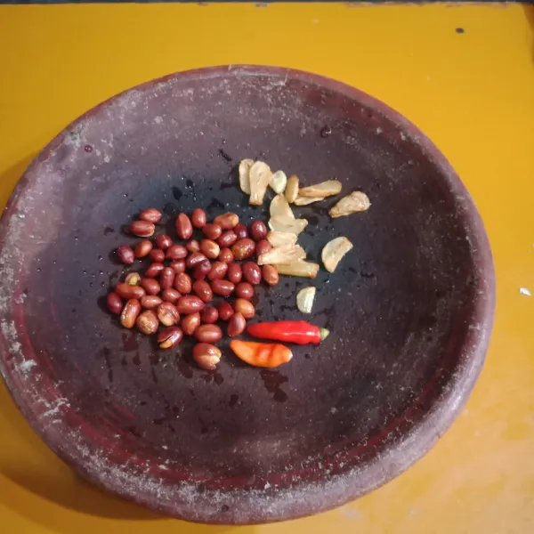 Siapkan cobek, ulek kacang tanah, bawang goreng dan cabe sampai halus.