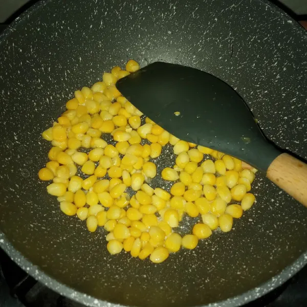 Panaskan mentega. Tumis jagung sampai matang.