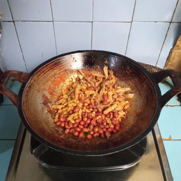 Masukkan tempe goreng, kacang tanah goreng dan ikan teri goreng.