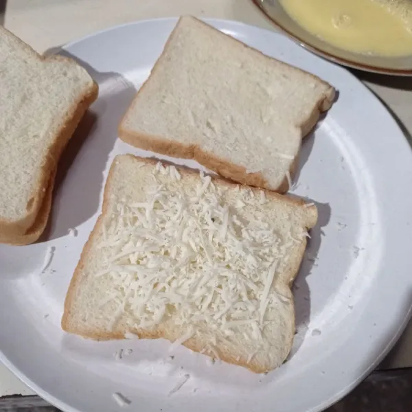 Siapkan roti tawar, tiap bagian beri isian keju parut dan satu bagian lagi beri isian mesis coklat, tumpuk dengan roti tawar lainnya, sisihkan.