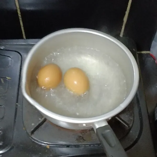 Rebus telur hingga matang angkat dan Kupas kulitnya.