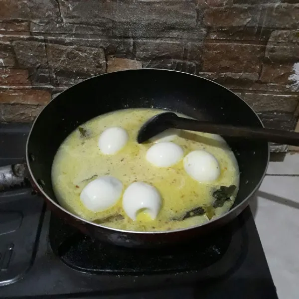 Lalu masukkan telur rebus tadi dan tambahkan kaldu bubuk, gula dan garam. Aduk rata. Masak hingga matang. Angkat dan sajikan.