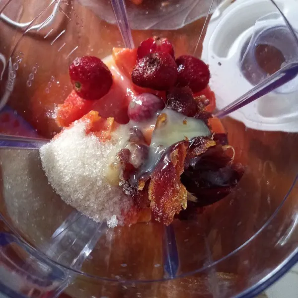 Masukkan pepaya, strawberry, kurma, gula pasir, es batu dan susu kental manis ke dalam wadah blender.