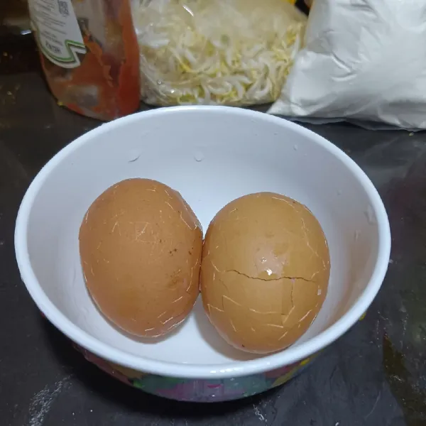 Angkat telur kemudian pukul perlahan menggunakan sendok ke seluruh permukaan telur hingga kulitnya retak.