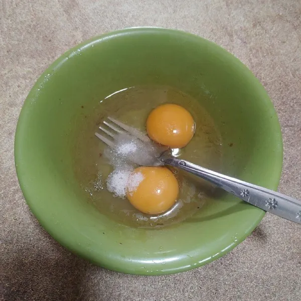 Pecahkan telur, beri garam dan kaldu bubuk. Kocok hingga berbusa dan garam larut.