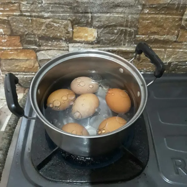 Rebus telur hingga matang lalu kupas kulitnya.