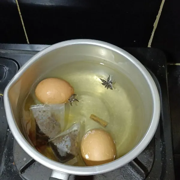 Masukkan kembali telur ke dalam air yang telah diberi bunga lawang kayu manis dan teh.