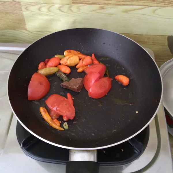 Goreng cabe rawit, tomat, terasi hingga matang.