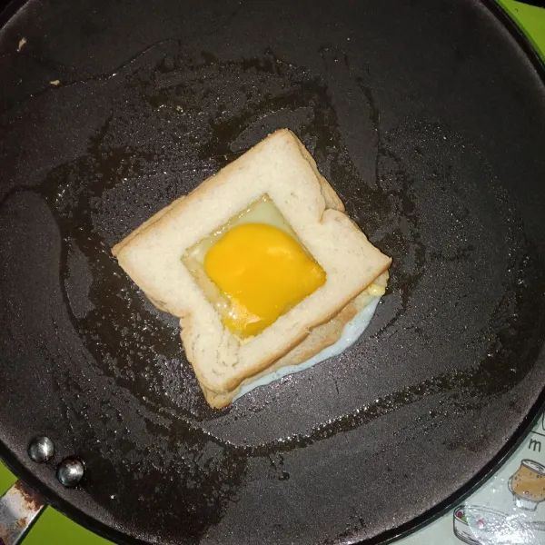 Panaskan pan, lalu taruh roti dan tuang telur.