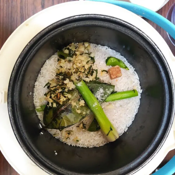 Tumis semua bumbu nasi kulit jeruk hingga layu dan harum, lalu masukkan ke dalam wadah yang berisi beras, tambahkan air, garam dan kaldu bubuk lalu masak menggunakan magic com hingga matang. Ambil nasi lalu bentuk bola-bola dan tusuk dengan tusuk sate. Sajikan.