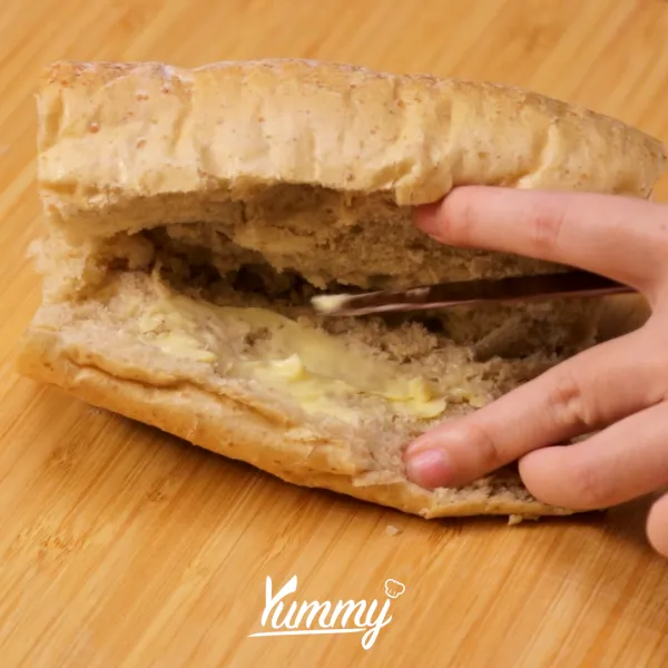 Potong roti french baguette dengan ukuran sesuai keinginan dan belah tengah roti menjadi dua. Oleskan bagian tengah roti dengan margarin, lalu panggang di wajan menggunakan api sedang. Angkat dan sisihkan.