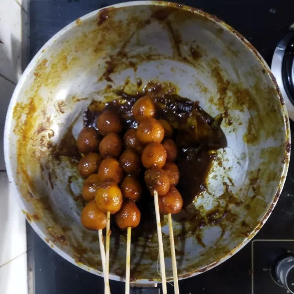 Setelah dingin, tusuk telur puyuh dengan tusukan sate. Sate siap disajikan.