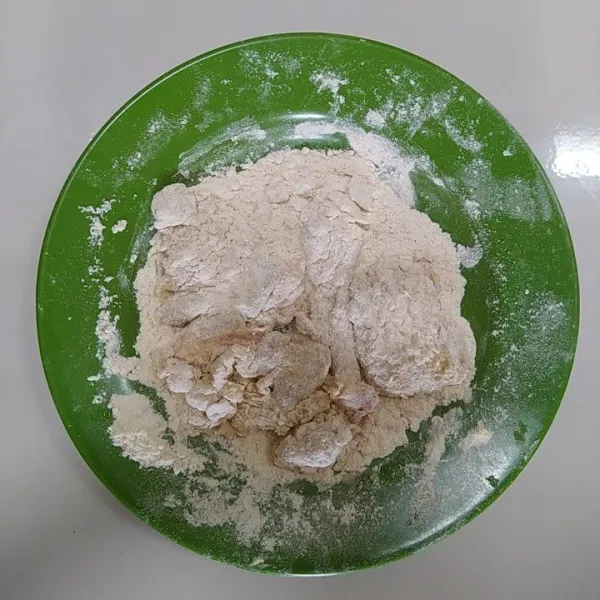 Lumuri kulit ayam dengan adonan kering (tepung bumbu) hingga merata.