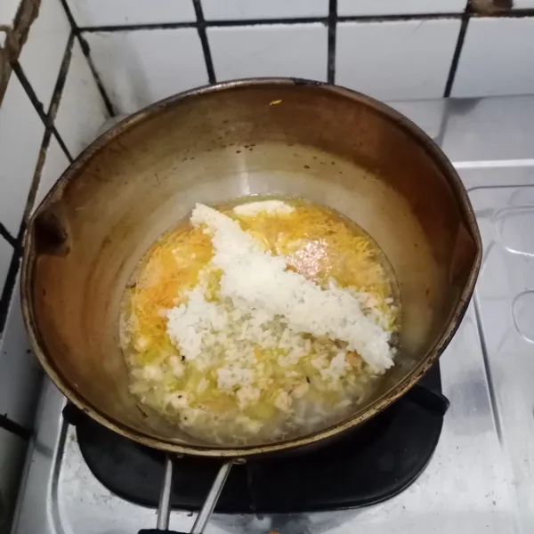 Lalu masukkan nasi dan tutup. Masak hingga nasi menjadi lembek atau sesuai selera.