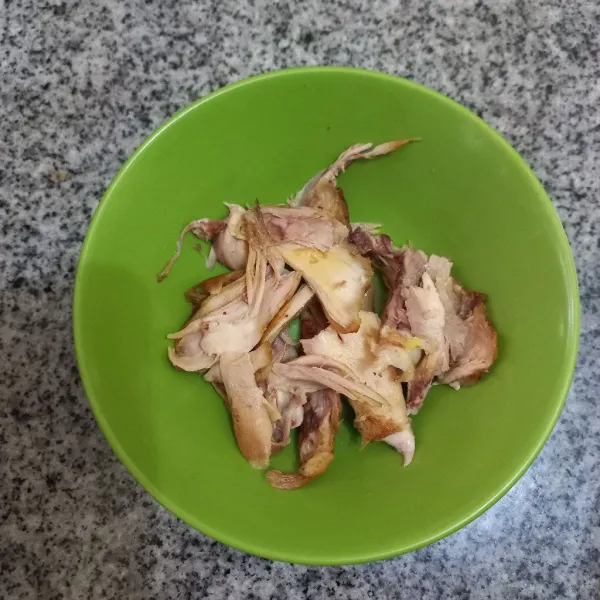 Suwir besar-besar ayam goreng dan pisahkan dengan tulangnya.