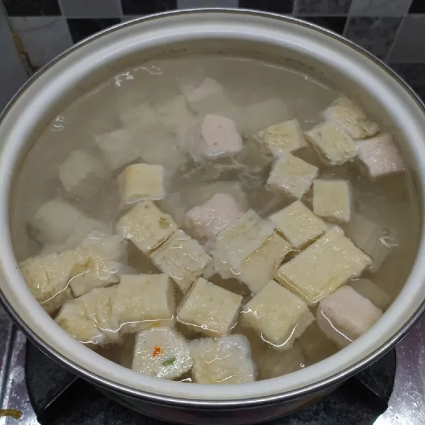 Rebus air sampai mendidih, masukkan tahu sutra dan fish cake.