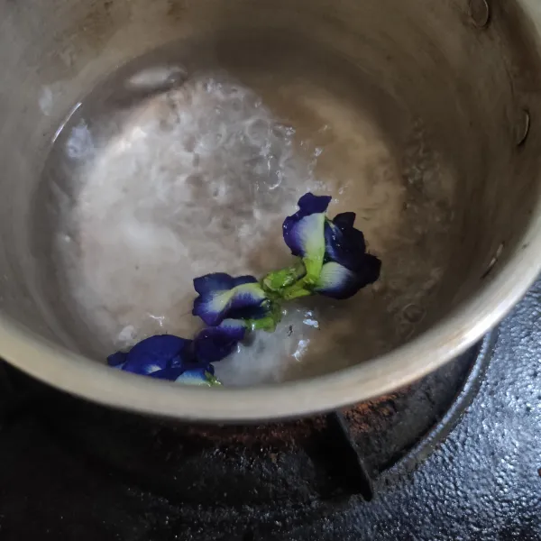 Rebus air hingga mendidih lalu masukkan bunga telang, masak hingga mendidih lalu dinginkan dan saring