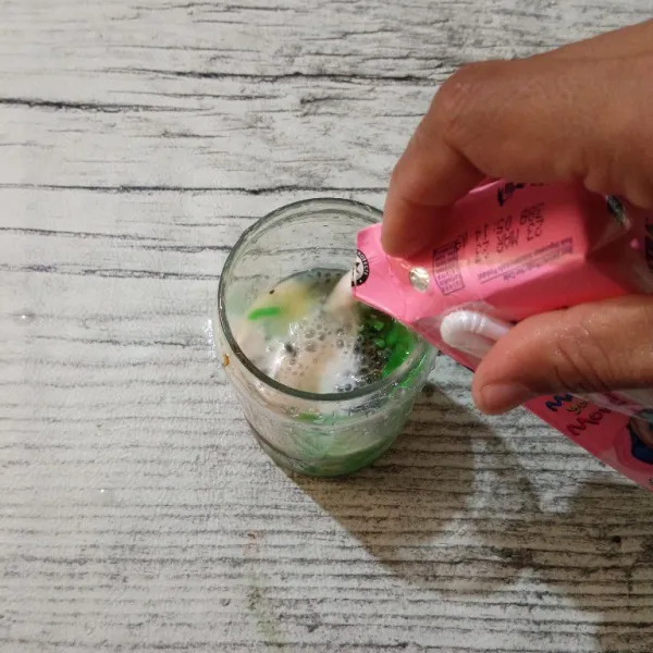 Tuang susu cair stroberi ke dalam gelas saji, aduk sebelum dinikmati.