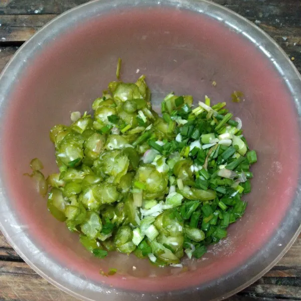 Siapkan wadah, potong daun bawang dan belimbing wuluh (peras-peras sedikit, buang airnya).