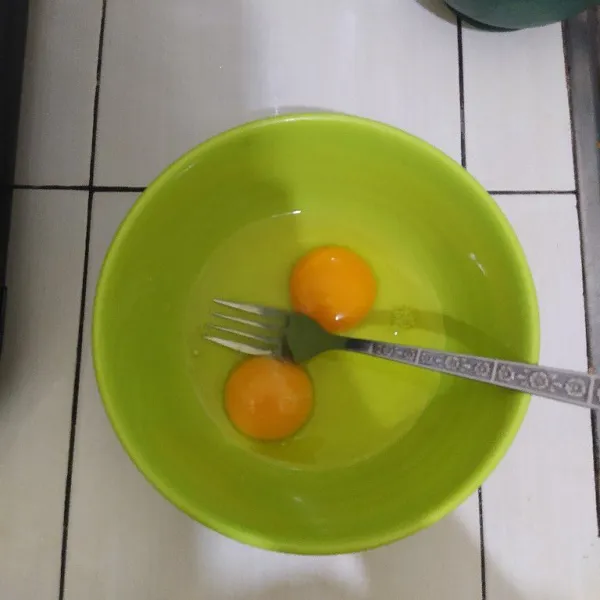 Pecahkan 2 butir telur lalu kocok lepas.