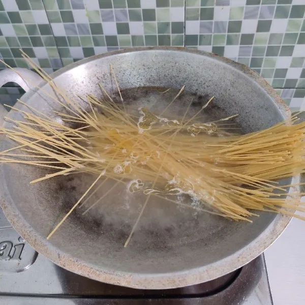 Rebus spaghetti dalam air mendidih hingga aldente, kemudian angkat dan tiriskan minyaknya.