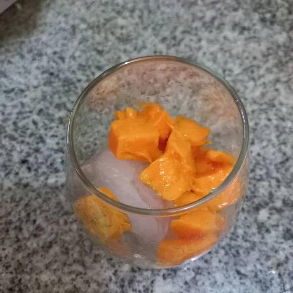 Masukkan potongan buah mangga juga ke dalam gelas.