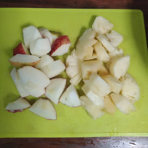 Potong-potong buah apel dan nanas. Untuk buah nanas, dicuci dulu dengan air garam supaya tidak gatal.