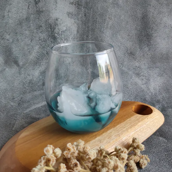 Siapkan gelas saji masukkan es batu dan juga sirup biru.