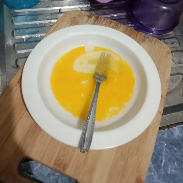 Kocok telur bersama garam dan kaldu jamur dengan garpu.