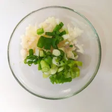 Cincang bawang putih dan iris daun bawang prei.