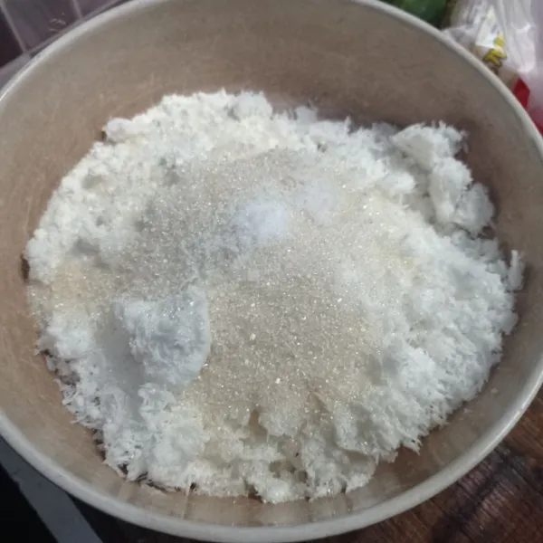 Campur tepung terigu, kelapa parut, gula pasir, garam dan vanili bubuk ke dalam wadah.