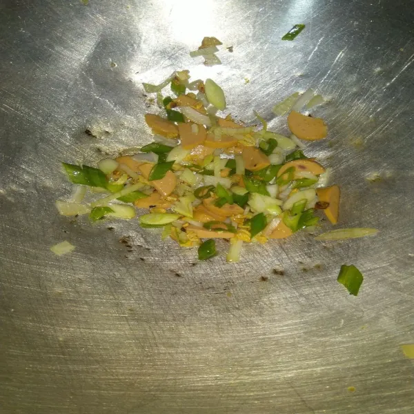Masukkan sosis, daun bawang dan bawang bombay, tumis hingga bawang layu.