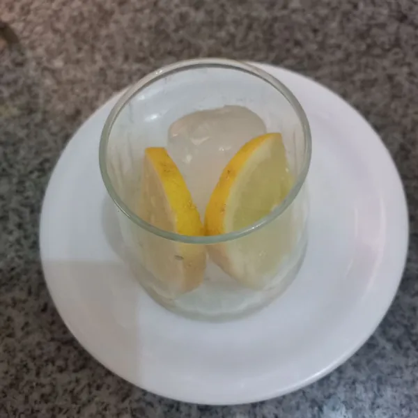 Masukkan es batu dan irisan jeruk lemon pada gelas.