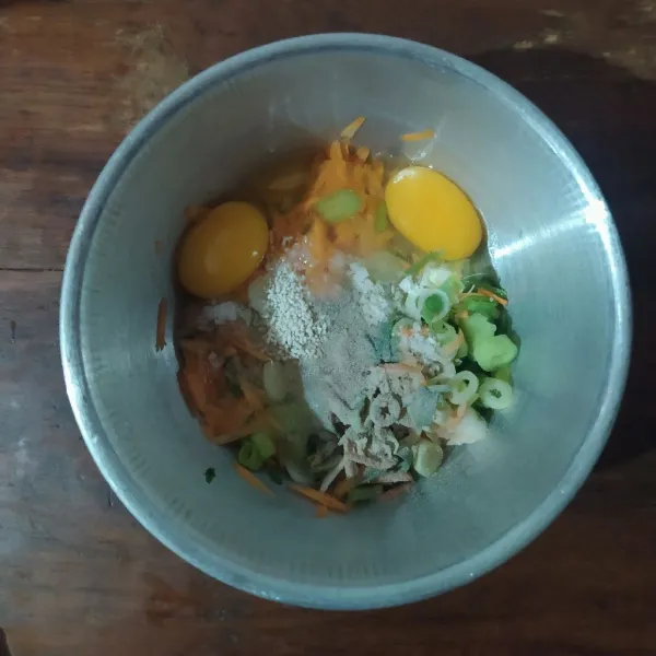 Kocok telur lalu masukkan wortel serut, irisan daun bawang, garam, lada, bawang putih bubuk dan kaldu jamur.