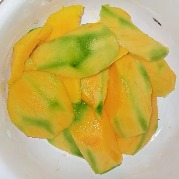 Potong tipis mangga, sisihkan.