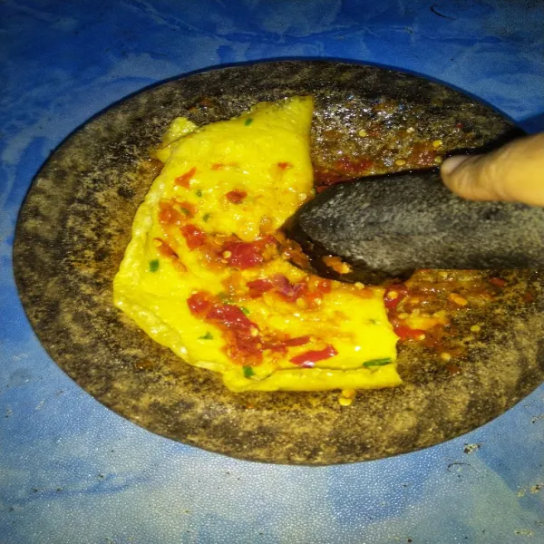 Letakkan telur diatas cobek yang berisi sambal. Kemudian geprek menggunakan ulekan. Sajikan dengan nasi panas.