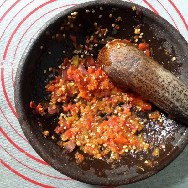 Panaskan minyak sampai benar-benar panas. Lalu tuangkan ke sambal dan aduk merata serta cicipi rasanya.