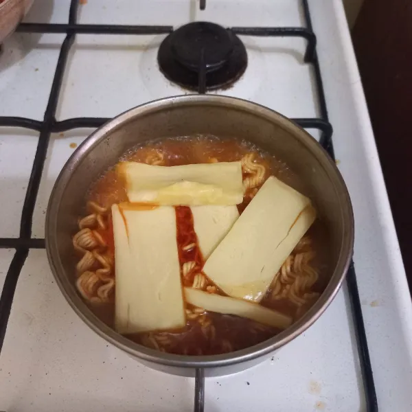 Masukkan potongan keju mozarella, tutup panci beberapa saat hingga keju mozarella meleleh.