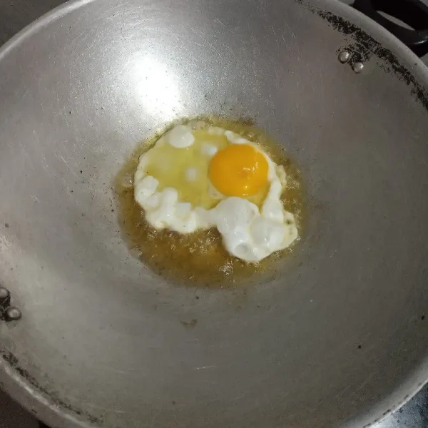 Masak telur ceplok sampai setengah matang.
