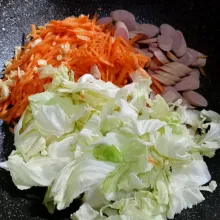Masukkan kol, sosis dan wortel. Aduk-aduk.
