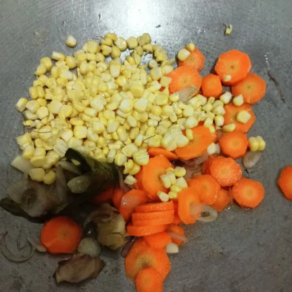 Masukkan jagung dan wortel. Tambahkan garam, kaldu bubuk, gula, aduk rata.