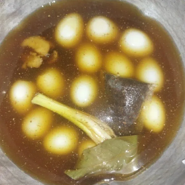 Siapkan panci, masukkan telur puyuh, teh celup, serai, daun salam, lengkuas, kecap manis, gula merah dan garam, lalu masak sambil sesekali diaduk-aduk.