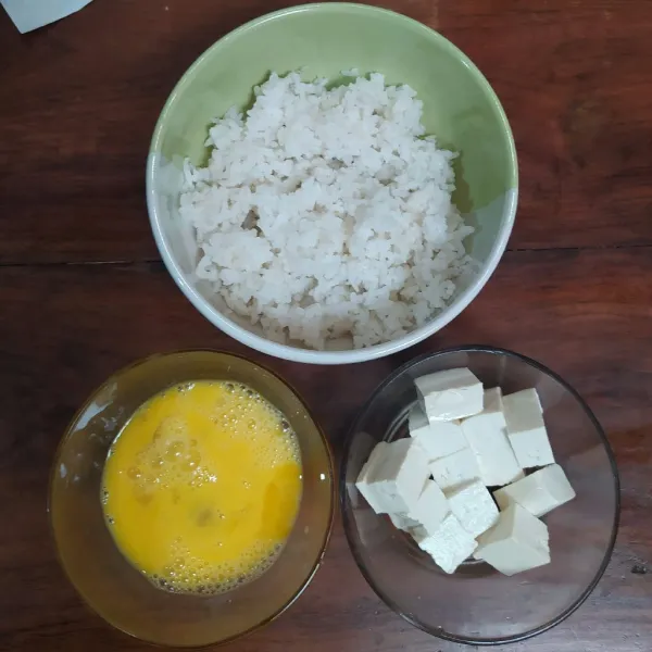 Siapkan 1 mangkok nasi panas, 1 butir telur kocok dan 1 kotak tahu putih yang dipotong dadu.