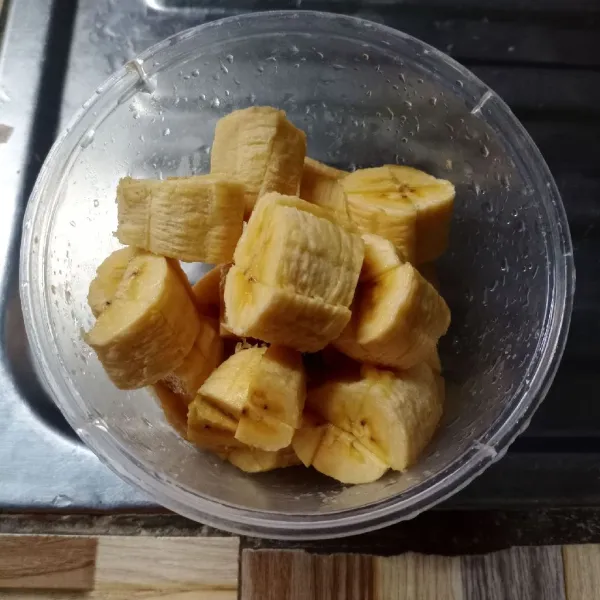 Belah pisang menjadi 4 bagian, kemudian potong-potong.