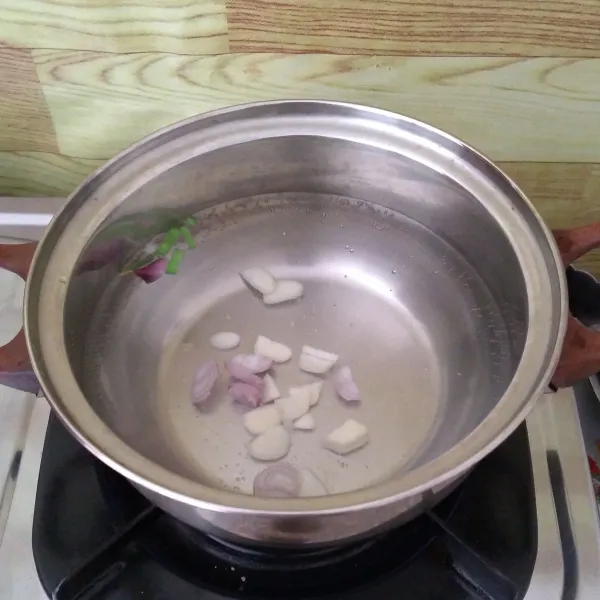 Rebus air hingga mendidih lalu masukkan irisan bawang putih dan bawang merah hingga aromanya harum.